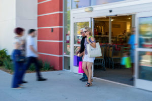 man and woman walk out of store in Millenia