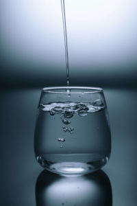 stream of water flows down into clear glass cup