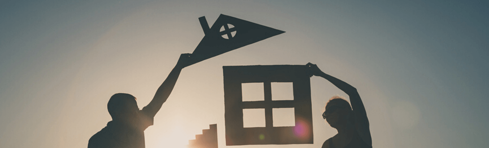 family holding cutouts of a house